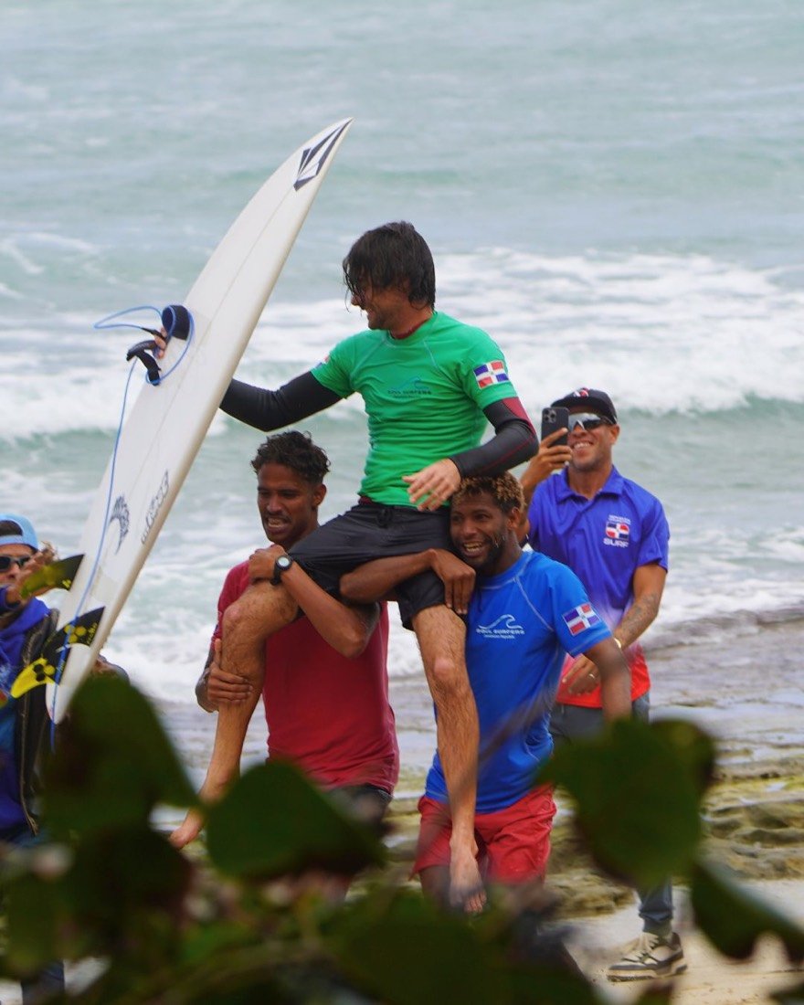 El ganador de un concurso de surf llevado en hombros por sus amigos en la playa de Cabarete, República Dominicana