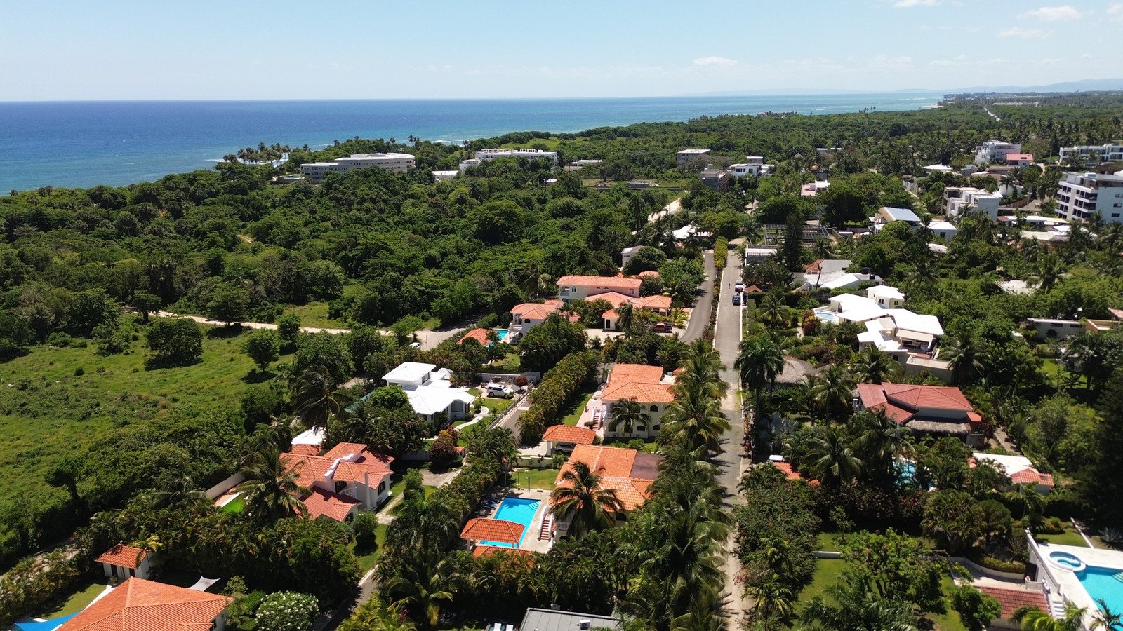 Vista con drone de una zona residencial con piscinas y el mar en el horizonte, Costa Norte de República Dominicana
